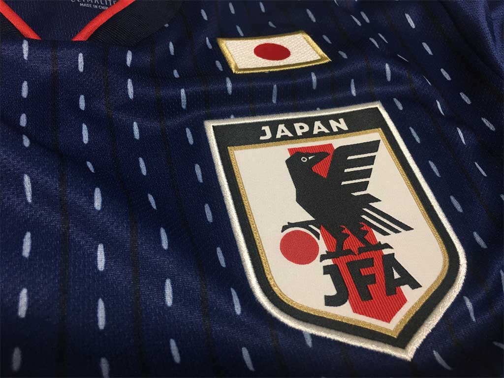 Vネックの赤と白いエンブレムが際立つ